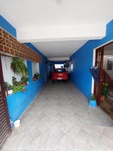 un garage avec une voiture rouge dans un mur bleu dans l'établissement Pousada Recanto do Coruja, à São Gabriel 4 autres photos