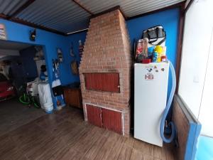 a room with a refrigerator and a brick wall at Pousada Recanto do Coruja in São Gabriel