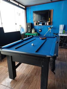 a pool table in a room with a blue wall at Pousada Recanto do Coruja in São Gabriel