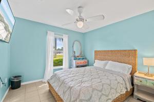 a blue bedroom with a bed and a window at Beachside Serenity Escape - Private 3BR and 2BA, DOG FRIENDLY Duplex Oasis, Steps to Shore! in Melbourne