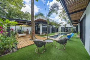an external view of a house with a garden and a patio at Playa Potrero - NEW modern house, pool in guitar shape - Casa Guitarra in Potrero