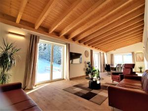 un soggiorno con soffitto in legno e un soggiorno arredato. di Landhaus am Schindelberglift a Oberstaufen