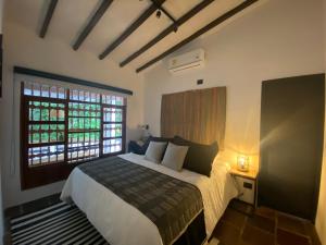 a bedroom with a large bed and a window at Casa Medallo in Medellín