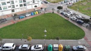 a large grassy area with cars parked in a parking lot at Hotel Avenida in Pontevedra