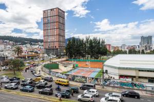 Una ciudad con muchos coches aparcados en un estacionamiento en MINI APARTAMENTO, Netflix, Disney Plus, sector privilegiado, cerca de todo, en Quito