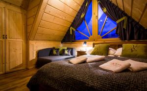 une chambre avec un lit et une grande fenêtre dans l'établissement Myśliwski Domek pod Giewontem, à Zakopane