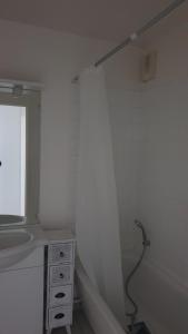 La salle de bains blanche est pourvue d'un lavabo et d'une fenêtre. dans l'établissement l'hippocampe, à Cayeux-sur-Mer