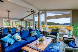 a living room with a blue couch and a table at Oasis By The Sea in Port Hadlock