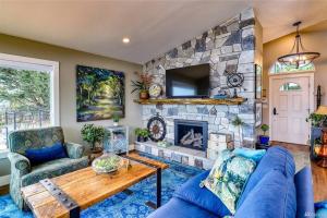 a living room with a stone fireplace and blue couches at Oasis By The Sea in Port Hadlock