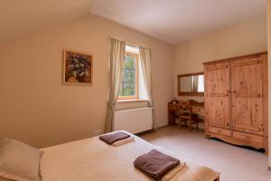 a bedroom with a bed and a window and a desk at Juku Dzirnavas in Zutēni