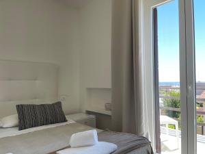 um quarto com uma cama e uma grande janela em Villa Angela Suite em Taranto