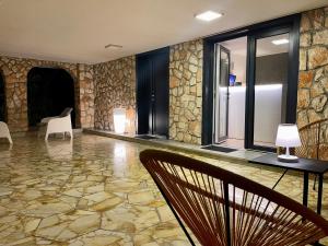 um quarto com uma parede de pedra com cadeiras e uma mesa em Villa Angela Suite em Taranto
