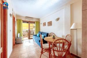 sala de estar con mesa y sofá azul en Apartamentos Marino Casa Azahar, en Alcossebre