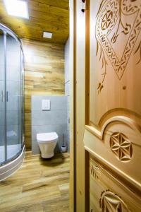 une salle de bain avec toilettes et douche en verre dans l'établissement Myśliwski Domek pod Giewontem, à Zakopane