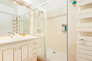 La salle de bains blanche est pourvue d'une douche et d'un lavabo. dans l'établissement Eat - Sleep - Wander Chic and Cosy Flat, à Nice