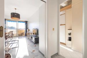 Eat - Sleep - Wander Chic and Cosy Flat في نيس: غرفة بيضاء كبيرة مع مطبخ وغرفة معيشة