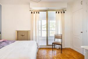 sypialnia z łóżkiem, krzesłem i oknem w obiekcie Eat - Sleep - Wander Chic and Cosy Flat w Nicei