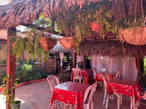um restaurante com mesas e cadeiras com toalha de mesa vermelha em Pousada Vitória do Lopes em Barreirinhas