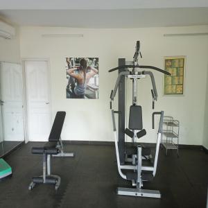 a gym with two tread machines and a woman in a picture at Paradise Appartment hotel in Mutumba