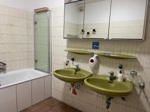 a bathroom with two green sinks and a shower at Pension Rüge in Frankfurt