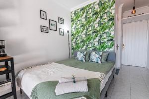 1 dormitorio con 1 cama con un mural de plantas en la pared en Puerto Rico Corner, en Puerto Rico de Gran Canaria