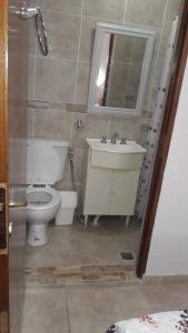 y baño con aseo, lavabo y espejo. en Alojamiento Guemes en Gualeguay