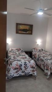 um quarto com duas camas e uma foto na parede em Alojamiento Guemes em Gualeguay