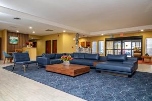 sala de estar con sofá azul y mesa en Endeavor Inn & Suites, Trademark Collection by Wyndham en Topeka