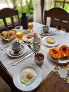 uma mesa com pratos de comida para o pequeno almoço em Pouso Araris - Araras, Vale das Videiras em Petrópolis