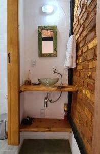 baño con lavabo y pared de ladrillo en Pouso Araris - Araras, Vale das Videiras, en Petrópolis