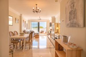 comedor y sala de estar con mesa y sillas en Ático familiar con terraza y bonitas vistas al mar en Marbella - Rio Real 282G, en Marbella