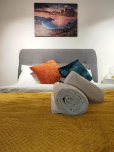 a bed with a pile of pillows and a blanket at Leicester Luxury Apartments - T45 in Leicester