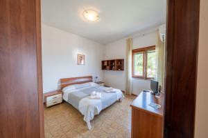 a bedroom with a bed and a desk and a television at Il Rifugio Del Merlo in Amalfi