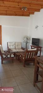 sala de estar con muebles de madera y sofá en Complejo Reliqua Dunamar Claromeco en Balneario Claromecó