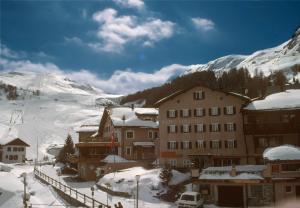 eine Gruppe von Gebäuden im Schnee neben einem Berg in der Unterkunft Hotel Solaria in Bivio