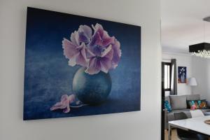 a painting of a vase with purple flowers in it at CASA CUADERNA a 150 metros de la playa in Playa Honda +30 photos