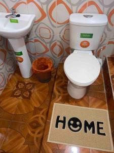 a bathroom with a toilet and a sink and a sign that says home at Dpto en Grazota Norte de Guayaquil in Guayaquil