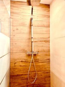 a shower with a hose attached to a wooden wall at Cocon De l'Est II in Saint-Benoît