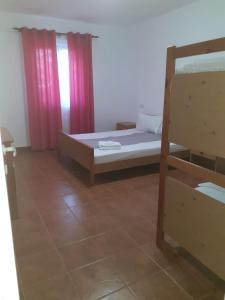 a bedroom with a bed and a window with a red curtain at APARTAMENT BELUX in Eforie Sud