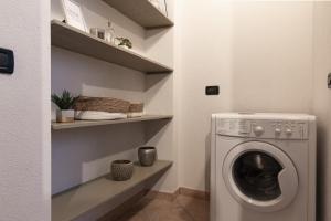 - une buanderie avec un lave-linge et des étagères dans l'établissement Grazioso appartamento in centro storico Chiari, à Chiari