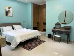 Schlafzimmer mit einem Bett, einem Spiegel und einem Tisch in der Unterkunft TD’s place in Okinni