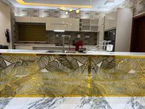 a kitchen with a gold and white counter top at TD’s place in Okinni