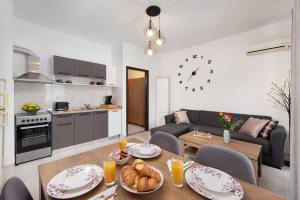 a kitchen and a living room with a table with food at Dolce Casa Suite1 in Afantou
