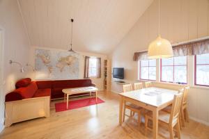 BruksvallarnaにあるBruksvallarna Lullens stugbyのリビングルーム(赤いソファ、テーブル付)