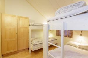 BruksvallarnaにあるBruksvallarna Lullens stugbyの二段ベッド2台とクローゼットが備わる客室です。