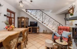 a living room with a table and a staircase at Angel Holiday House in Ravna Gora