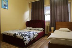 sypialnia z 2 łóżkami i czerwonym krzesłem w obiekcie Moon Hostel w Prisztinie