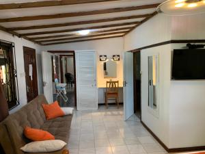 a living room with a couch and a flat screen tv at Amitie Chalets Praslin in Grand Anse