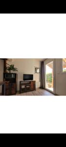 ein Wohnzimmer mit einem Fenster und einem Tisch in der Unterkunft Gîte climatisé avec Jardin privatif in Pignans