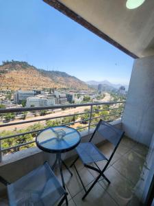a table and two chairs on a balcony with a view at Providencia Cercano a Clínicas y Hospitales in Santiago